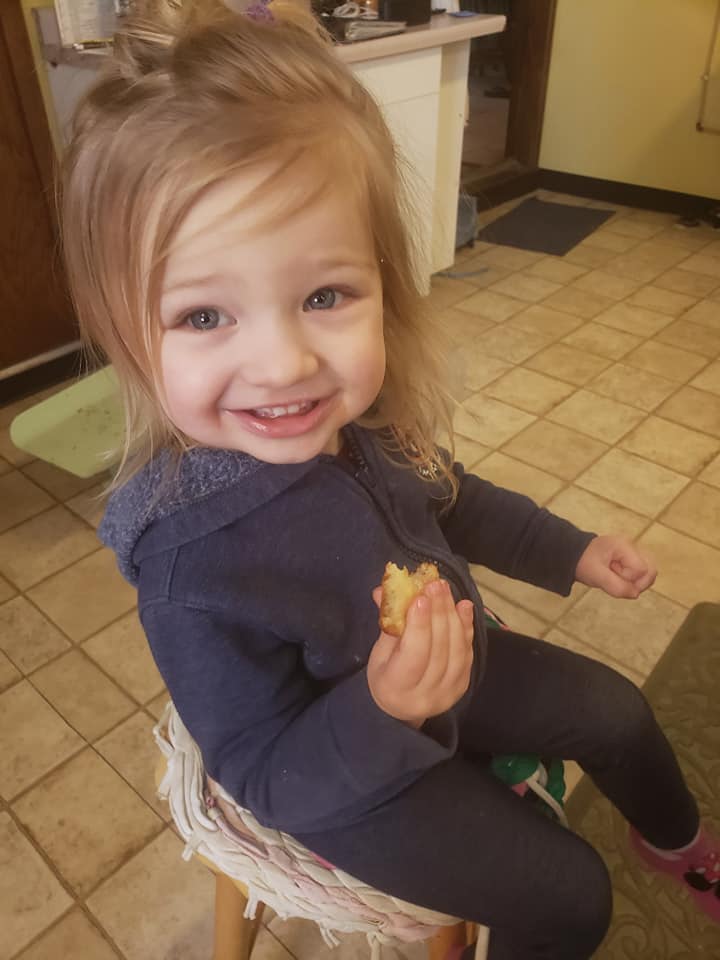 Granddaughter enjoying her doughnut with a big smile!