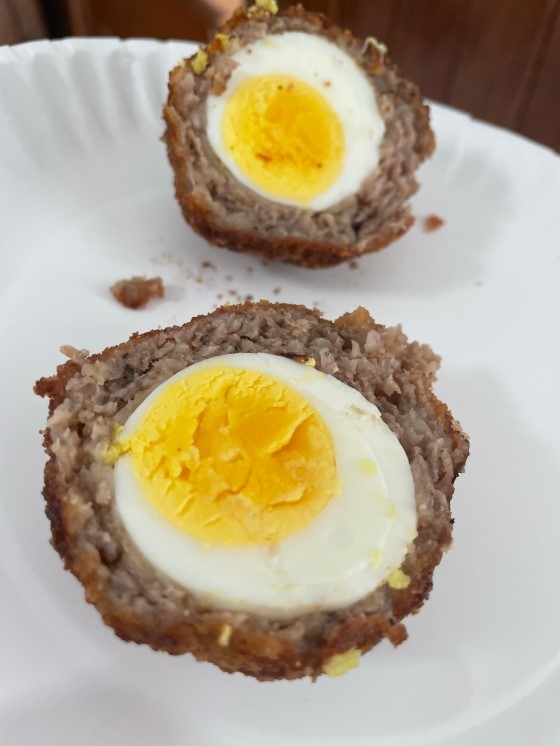 A Scotch egg, halved to reveal yummy insides