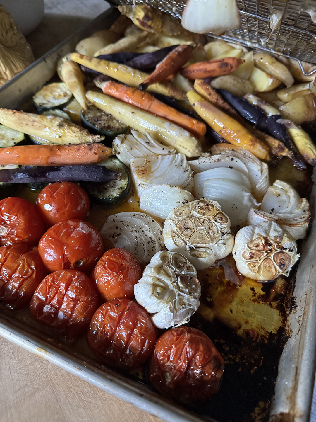 vegetables roasted on a sheet pan under chicken thighs